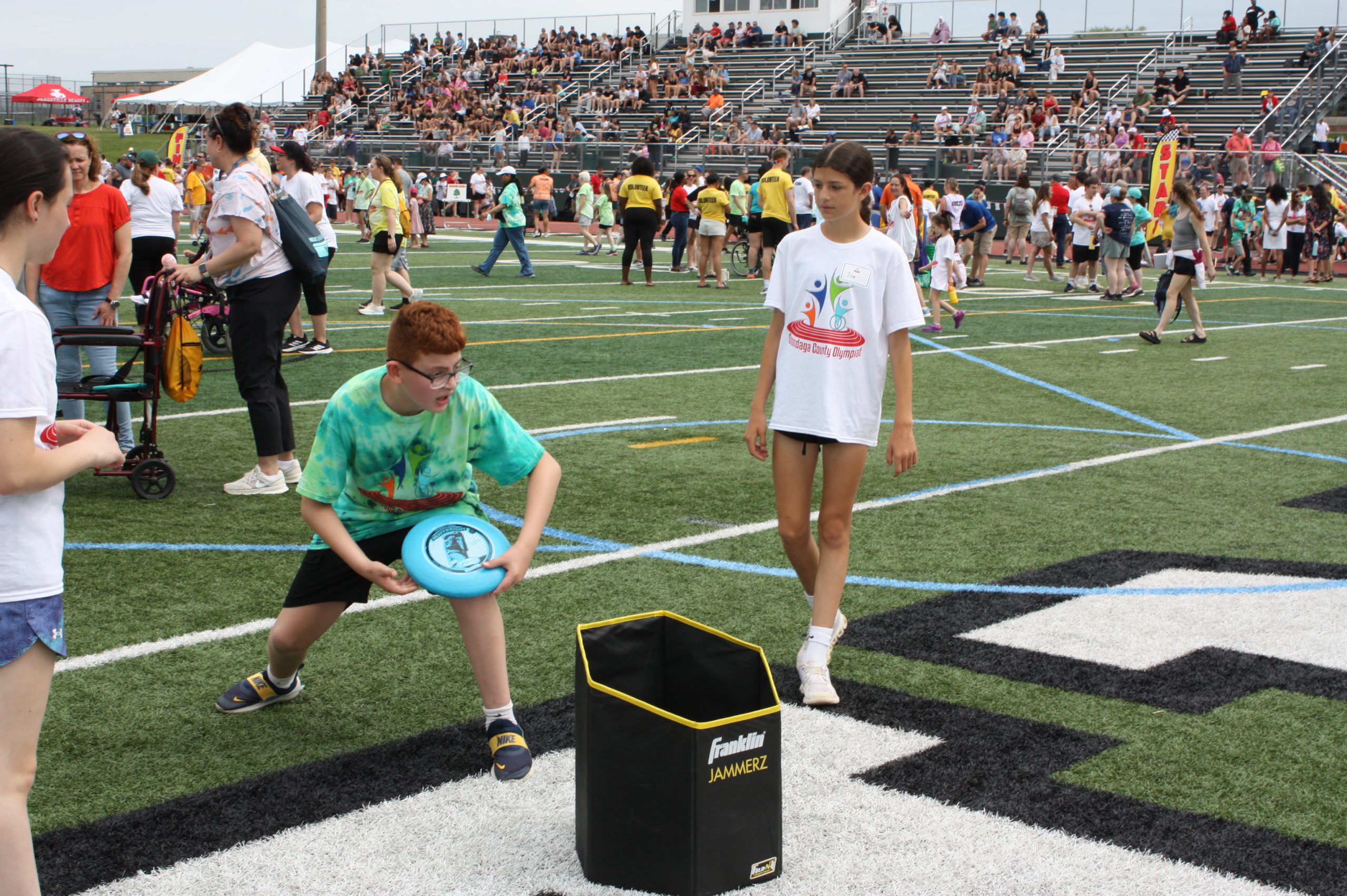 Student getting ready to throw frisbee with another student standing to his right watching.